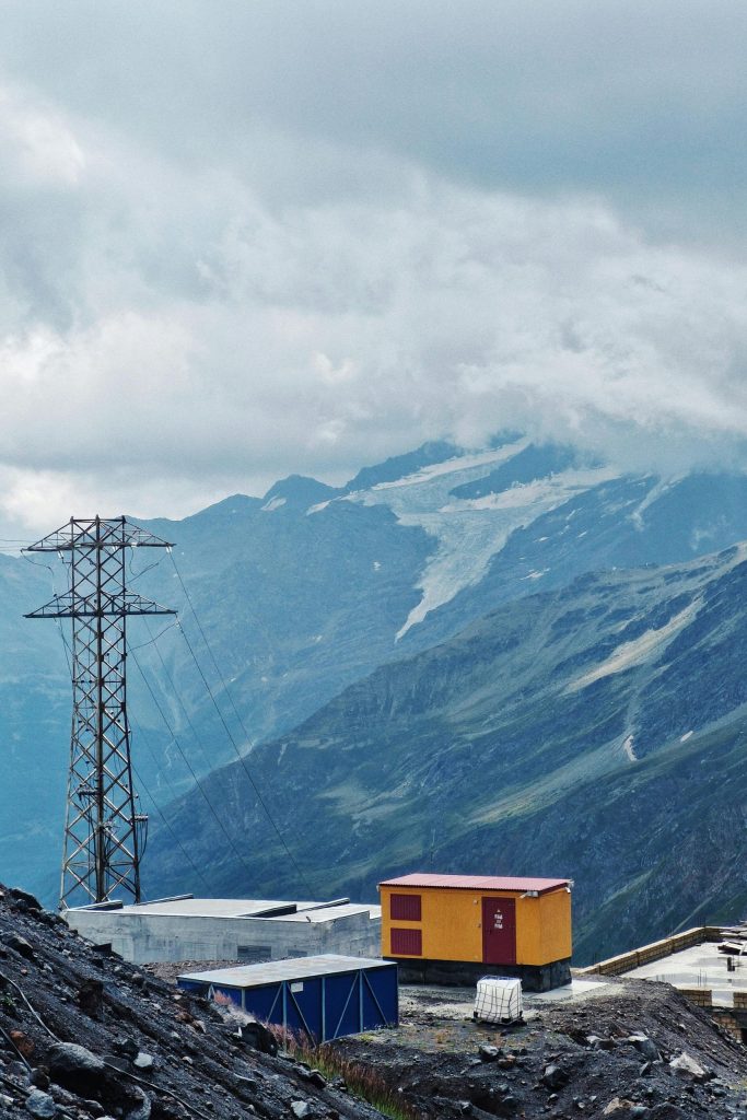 Scenic view of mountains with colorful buildings and electricity tower.